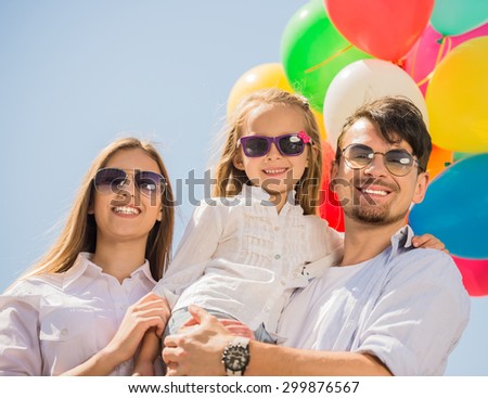 Happy family with little kid playing with balloons at the day time. Friendly family concept.
