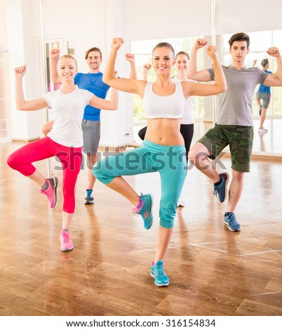 Fitness dance studio class. Group of people are exercising in dance studio.