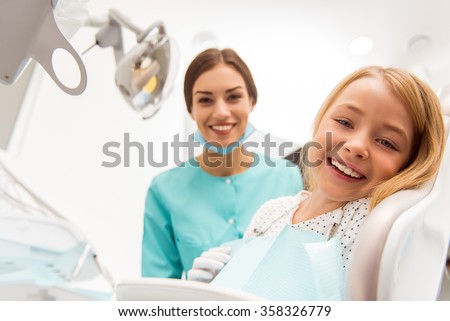 Little beautiful girl at the dentist looking at the camera and smiling