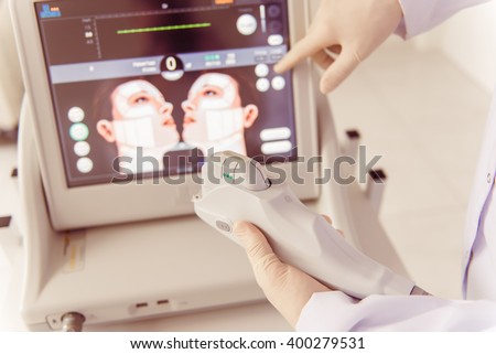 Doctor is holding a modern medical equipment for face skin treatment, close up
