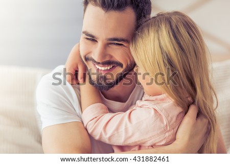 Portrait of handsome father and his cute daughter hugging and smiling