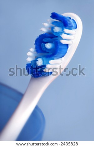 tooth brush in blue cup close up