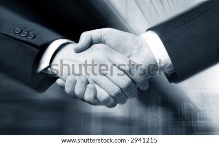 business hand shake and a office in background,  Suit slightly motion blur, focus at the hands