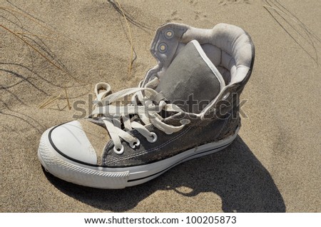 vintage age-worn sneaker on beach sand