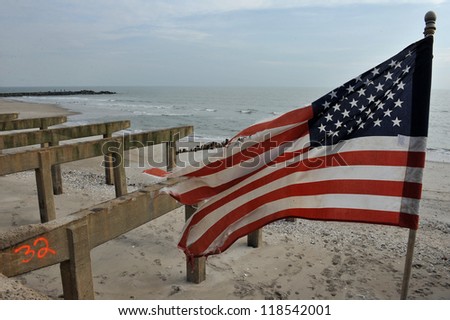 NEW YORK, NY - NOVEMBER 09: The destroyed boardwalk and a tattered American flag following Superstorm Sandy at Rockaway Beach on November 9, 2012 in the Queens borough of New York City.