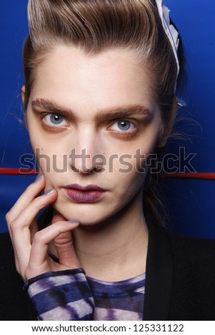 PARIS, FRANCE - MARCH 06: A model gets ready backstage at the Kenzo fashion show during Paris Fashion Week on March 6, 2011 in Paris, France.
