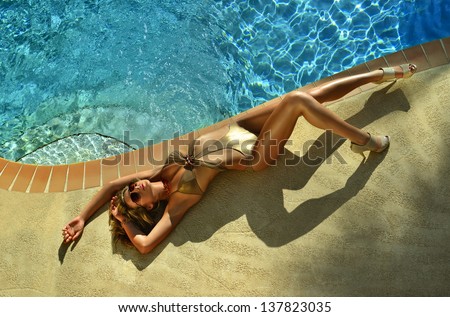 Fashion Model Posing Pretty By Swimming Pool Wearing Designers One Piece Swimsuit And Sunglasses