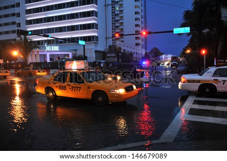 MIAMI BEACH, FL - JULY 18: Cars moving on flooded streets and roads of Miami South Beach  after heavy rains in Florida July 18, 2013 in Miami Beach, Florida