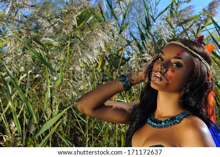 Attractive woman with native indian cherokee makeup and feathers in her hair