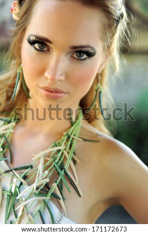 Attractive Blond woman with green bamboo nacklace on her chest