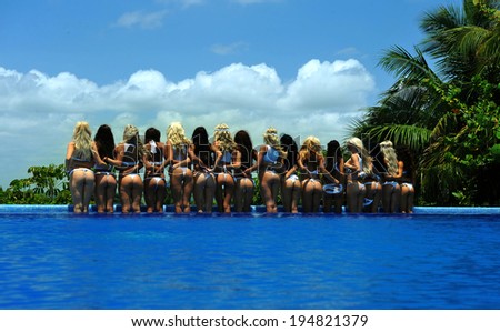 CANCUN, MEXICO - MAY 05: Models poses by the edge of pool for white t-shirt project during IBMS - International Bikini Model Search 2014 at the Oasis Sens Resort  on May 05, 2014 in Cancun, Mexico.