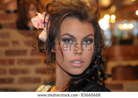 portrait of beautiful Fashion runway model with glamor make-up orchid flower in a hair