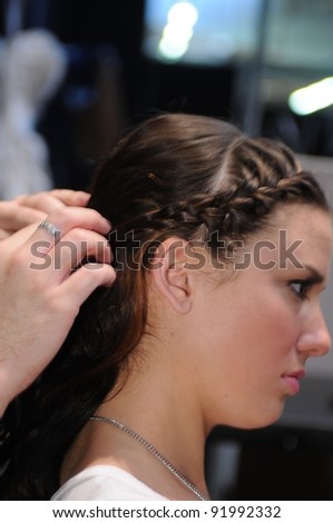 NEW YORK - OCTOBER 17: Model getting ready hairstyle backstage at the Winnie Couture Bridal Collection for Spring/ Summer 2012 during NY Bridal Fashion Week on October 17, 2011 in New York, USA