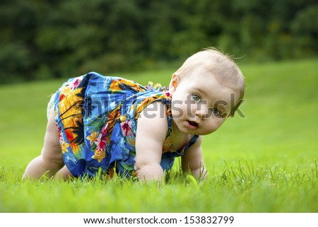 A Japanese American toddler girl learns to crawl outside