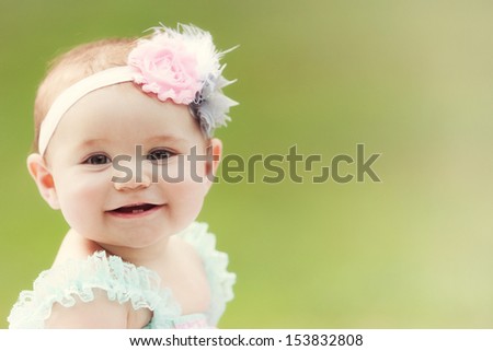 A Japanese-American toddler girl smiles at the camera outside