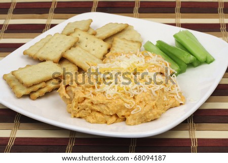 Appetizer buffalo chicken dip with crackers and celery