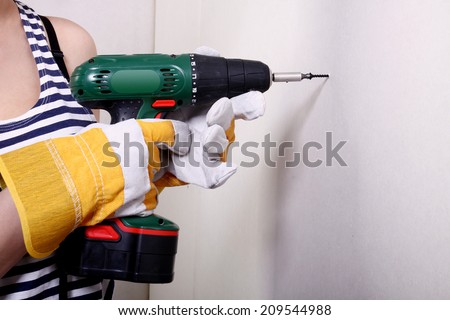 Electric drill touching wall, action concept