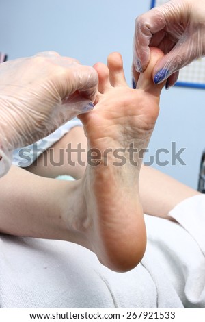 Nurse or care giver treating a senior woman\'s foot