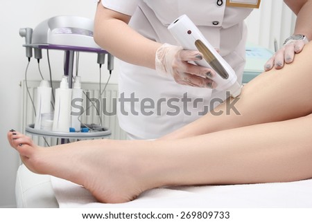 Young woman in Spa getting legs waxed for hair removal