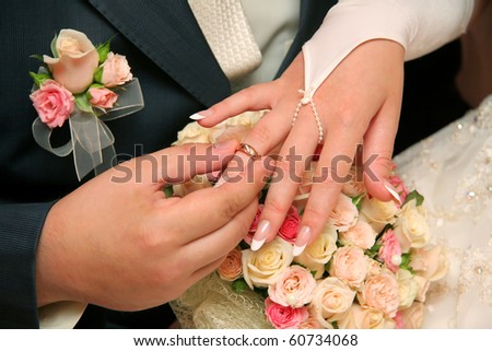 Groom puts wedding ring on bride\'s finger