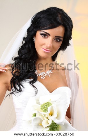 The beautiful bride with a bouquet of callas in studio