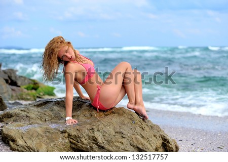 Young girl in a red dress on the ocean coast