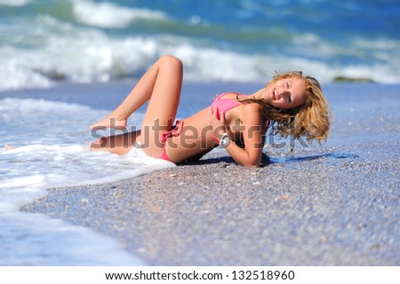 Young girl in a red dress on the ocean coast
