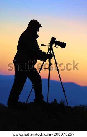 Silhouette of a landscape photographer in twilight