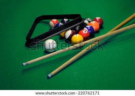 Top view of billiard balls and cues on green table