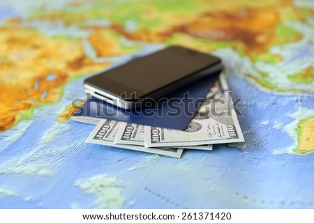 Phone, passport, money on a background map of the world. Traveling concept