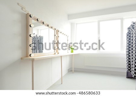 Room with makeup mirror lights and window