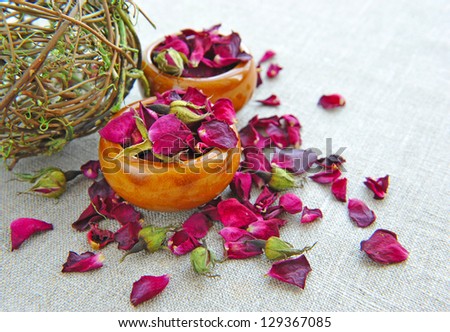 Dry healing flowers and petals in a cups on sackcloth, herbal medicine