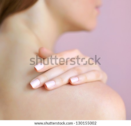 Beautiful woman with hand on shoulder. Focus is on a hand