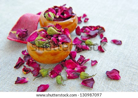 Dry healing flowers and petals in a cups on sackcloth, herbal medicine
