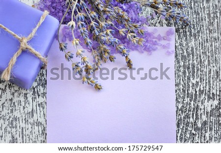 Lavender flower, soap, salt and blank paper on a wooden background