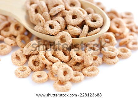 Wooden spoon with cereal rings on white background