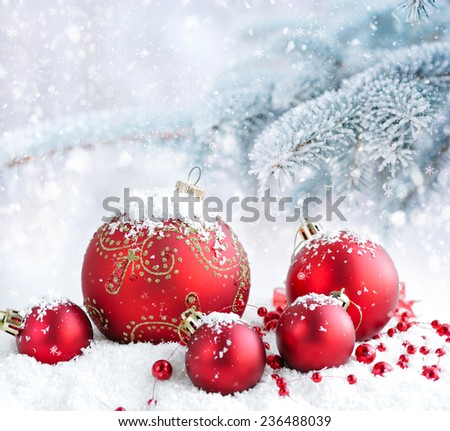 Christmas red balls on a background snow-covered fir branches
