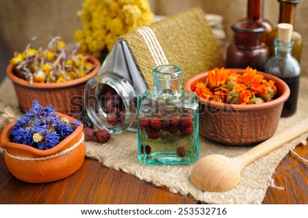 Healing herbs and tinctures in bottles on sackcloth, dried  flowers, herbal medicine