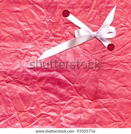 The white ribbon on the pink background of gift paper