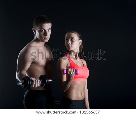 Young fitness models are posing in studio