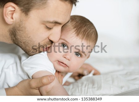 Young Father Is Playing With His Baby