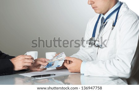 Closeup on medical doctor hands, taking money