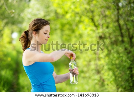 Athlete refreshing with a bottle of water during the outdoor exercise