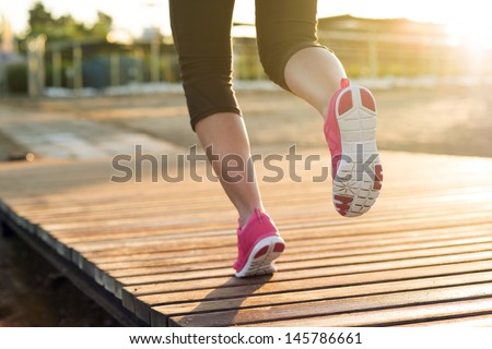 Young woman is running in sunny nature