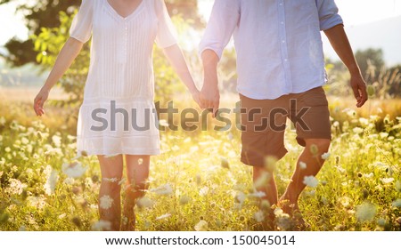 Happy And Young Pregnant Couple Hugging In Nature