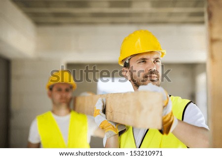 Construction workers collaborating on new house building