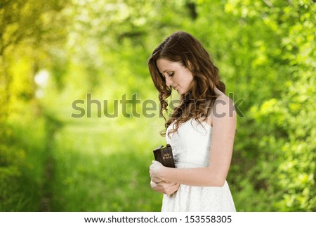 Beautiful woman with Bible is in sunny nature