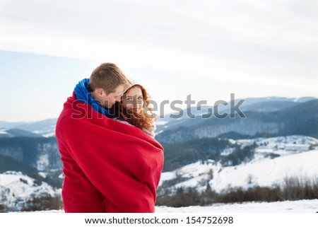 Happy young couple in mountains at winter holiday
