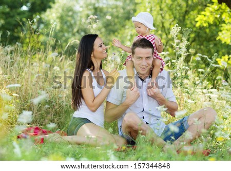Happy young family spending time together in green nature.