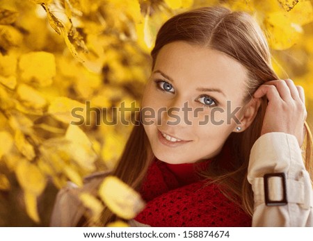 Portrait of beautiful girl in autumn park with yellow leaves